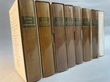 six books are lined up in a row on a white surface