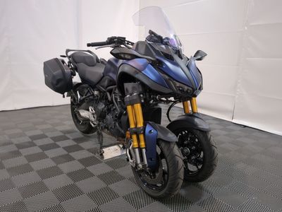 une moto qui est garée dans une pièce dont le sol est en damier