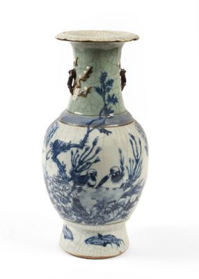 un vase bleu et blanc posé sur une surface blanche
