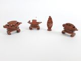 trois pièces de bois sculpté reposent sur une surface blanche
