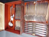 a wooden case with silverware in it and a spoon in it