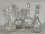 four clear glass bottles sitting next to each other on a white surface