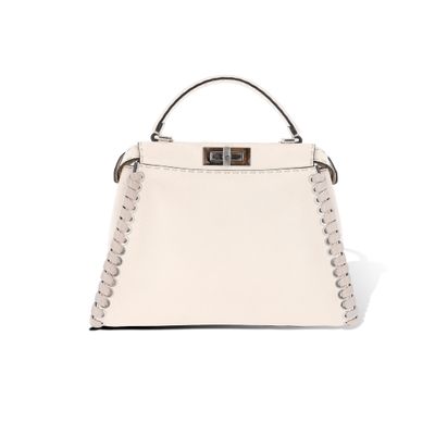 un sac à main blanc muni d'une poignée en métal et de rivets sur la poignée