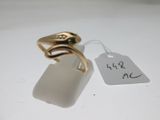 une bague en or ornée d'un oiseau, à côté d'une étiquette de prix
