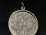 a close up of a silver coin on a black surface