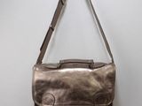 un sac en cuir marron accroché à un mur blanc