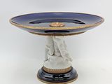 an image of a blue and gold plate with a statue on it