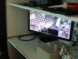 a computer monitor sitting on a shelf in the corner of a room