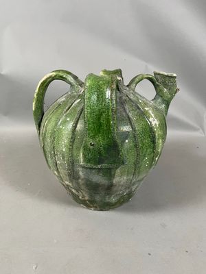 a green vase with a face on it on a white background