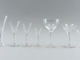 six wine glasses are lined up in a row on a white surface