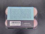 a package of three eggs sitting on a black surface