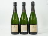 trois bouteilles de vin posées l'une à côté de l'autre sur une table