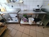 a kitchen with a stainless steel counter top and two buckets on the floor
