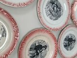 many plates on the wall with pictures of people on them