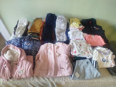 a lot of clothes that are sitting on a bed