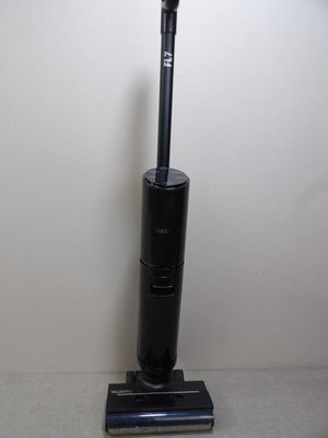 a black vacuum cleaner on the floor next to a white wall