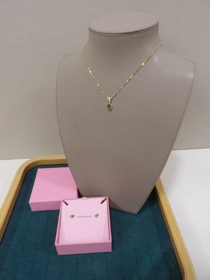un ensemble composé d'un collier et de boucles d'oreilles, présenté dans une vitrine posée sur une table