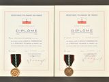 two medals and a certificate are on display on a table