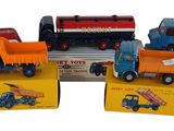 plusieurs camions jouets sont alignés sur une surface blanche