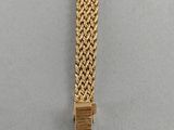 a gold bracelet with a square clasp