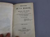 someone is holding a book open on a blue surface