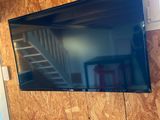 une télévision à écran plat accrochée au mur au-dessus d'un fauteuil rouge