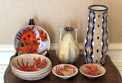 de nombreux vases et assiettes de toutes sortes sur la table
