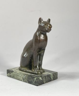 statue en bronze représentant un chat, posée sur un socle en marbre