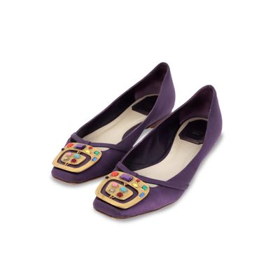 Les chaussures violettes sont ornées de boutons colorés et d'une boucle dorée.