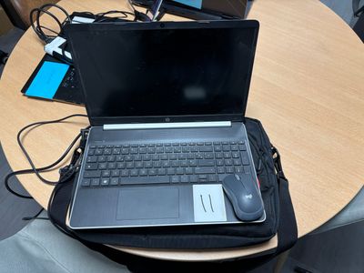 un ordinateur portable posé sur un sac, sur une table