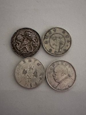 four different coins sitting on top of a white surface next to each other