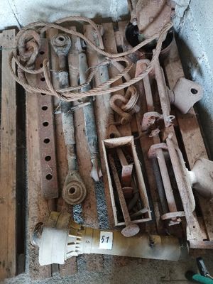 un tas de vieux outils posés sur une palette près d'un mur