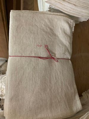 une pile de linge de lit plié posée sur un lit