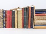 many books stacked on top of each other on a table