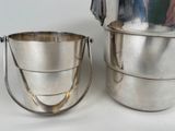 two metal buckets sitting next to each other on a table