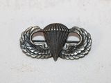 a close up of a metal pin with a parachute on it