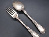 a pair of silverware spoons and fork on a black surface