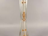 a glass vase that has a gold design on it