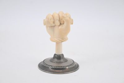 a small statue of a fist on a pedestal