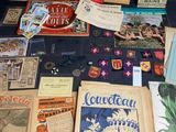 many books and pamphlets on a table with a blue table cloth
