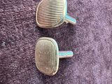 pair of gold tone cufflinks on a purple cloth