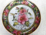 une photo d'une assiette décorée d'un colibri et de fleurs