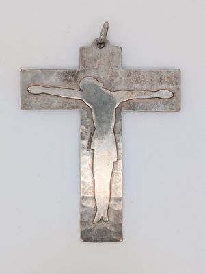 un gros plan d'une croix en métal sur laquelle se trouve une personne