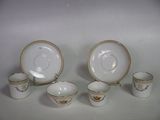 quatre tasses et soucoupes posées sur une table
