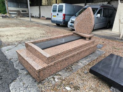 une voiture garée à côté d'une tombe en pierre