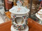 a tea pot and a cup on display in a glass case