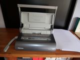 une imprimante posée sur un bureau, à côté d'une pile de papiers