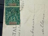 an old postcard with a green stamp on it sitting on a desk