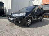 La petite camionnette noire est garée devant un immeuble.