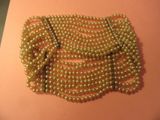 une photo d'un collier de perles sur un fond rose